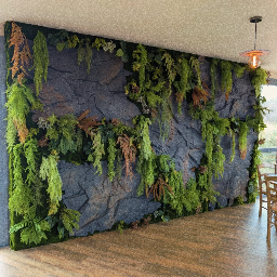 Mur végétal intérieur sur fond de panneaux effet pierre sombre
