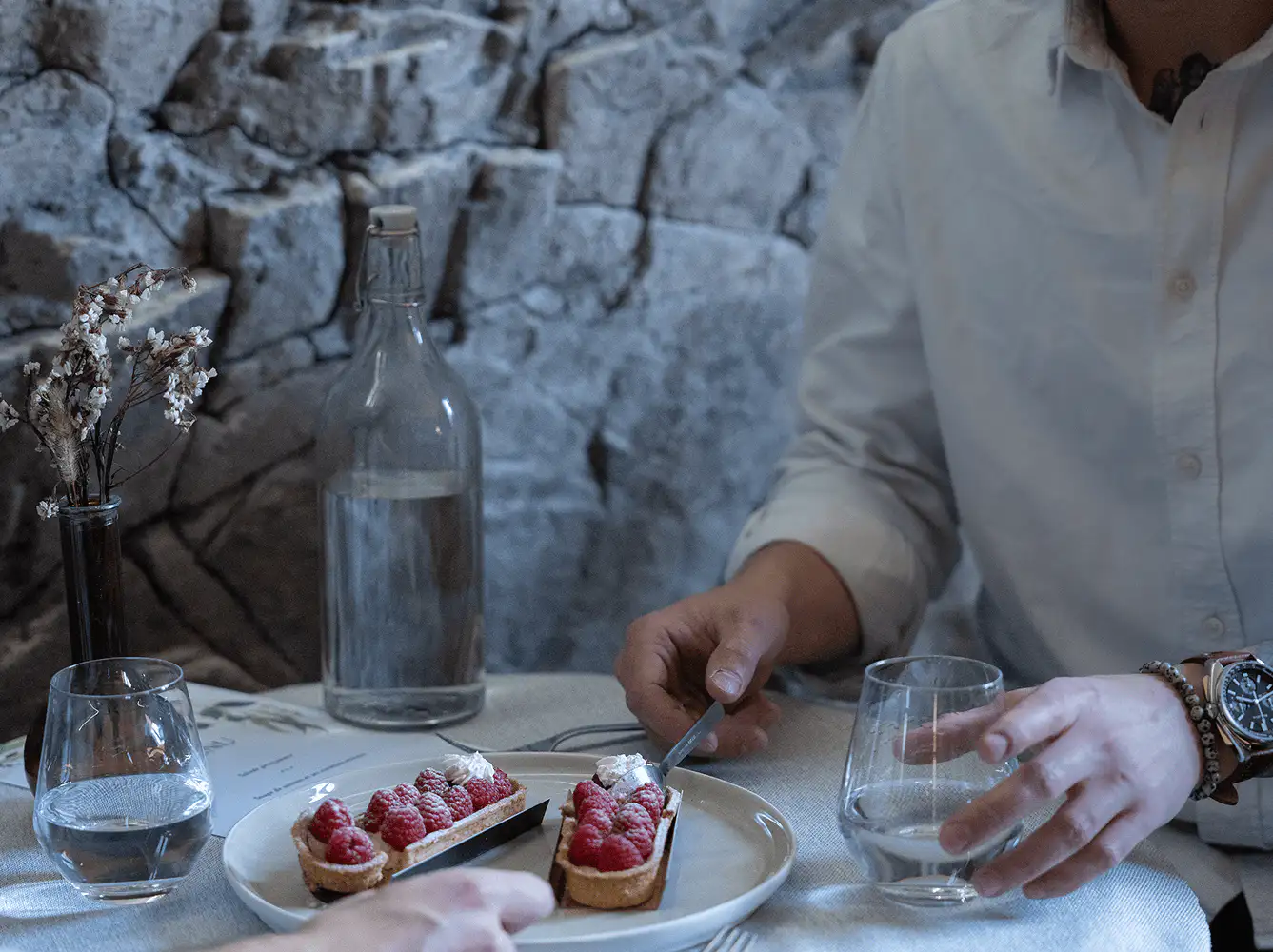 Salle à manger avec un mur en pierre réalisé en panneaux Óros
